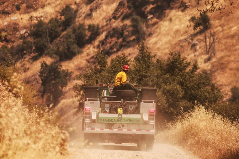 Image: A crew from the Sierra Hot Shots rides through as the Basin Fire burns 